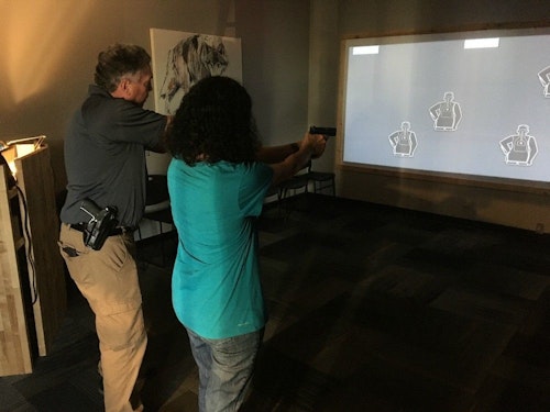 Claire learns how to properly aim a handgun in a virtual shooting range.